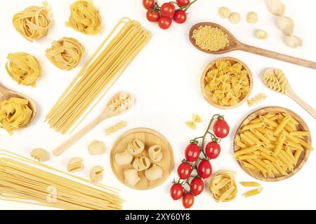 Ein Foto von verschiedenen Arten von Nudeln, wie Spaghetti, Penne, Fusilli und andere, mit Kirschtomaten, bilden einen Rahmen, geschossen von oben Stockfoto