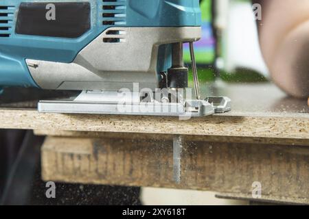 Elektrische Stichsäge für Holzsägen ein Stück Holz und Späne fliegen Stockfoto