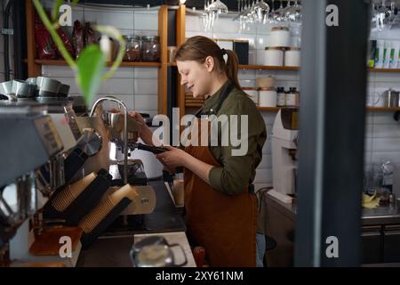 Eine Barista-Frau, die im Café Kaffee macht Stockfoto