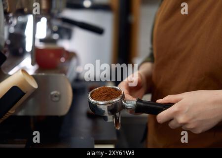 Barista hält Portafilter mit gemahlenen Bohnen bereit für die Zubereitung von klassischem Espresso Stockfoto