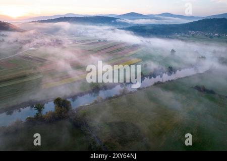 Aus der Vogelperspektive auf die Krka-Flussbiegung und ein wunderschönes Morgenlicht über den nebeligen Feldern und dem Fluss, Dolenjska Region, Dolenjske toplice, Slowenien Stockfoto