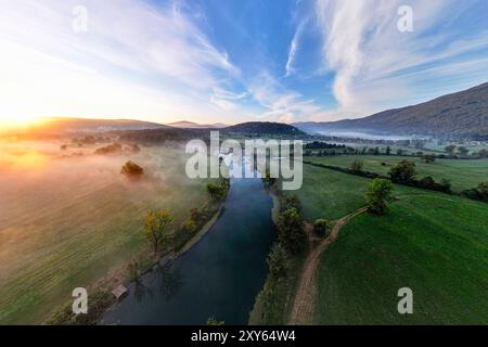 Aus der Vogelperspektive auf die Krka-Flussbiegung und ein spektakuläres Morgenlicht über den nebeligen Feldern und dem Fluss, Dolenjska Region, Dolenjske toplice, Slowenien Stockfoto