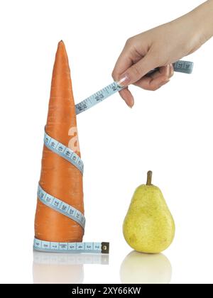 Frau mit einem Maßband um eine Karotte. Isoliert auf weiß. Gesunde Ernährung und Gewichtsreduktion Konzept Stockfoto