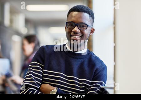 Porträt, Flur und Mann mit Brille, Bildung und stolz auf Stipendien für College und Lernen. Korridor, Universitätsstudent und Vision für Stockfoto