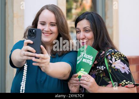 Dresden, Deutschland. August 2024. Ricarda lang (l), Bundesvorsitzende, und Pegah Edalatian (beide Bündnis 90/die Grünen), stellvertretende Bundesvorsitzende, stehen und machen ein Selfie während einer Wahlkampagne ihrer Partei am Schillerplatz. Quelle: Sebastian Kahnert/dpa/Alamy Live News Stockfoto