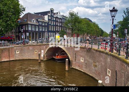 AMSTERDAM, NIEDERLANDE - 10. JULI 2017: Besucher besuchen den Herengracht-Kanal in Amsterdam, Niederlande. Amsterdam ist die Hauptstadt der Niederlande Stockfoto