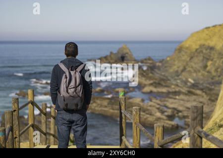 Mann mit Rucksack, der den Strand Praia dos Machados in Costa Vicentina, Portugal, Europa sieht Stockfoto