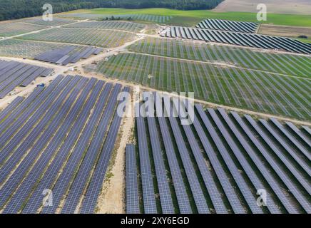 Petershagen, Deutschland. August 2024. Eine im Bau befindliche Photovoltaikanlage (Solarpark) auf einem ehemaligen Feld (Luftaufnahme mit Drohne). Auf einem Feld im Landkreis Märkisch-Oderland im Osten Brandenburgs wird hier seit mehreren Monaten ein großer Solarpark errichtet. Quelle: Patrick Pleul/dpa/Alamy Live News Stockfoto
