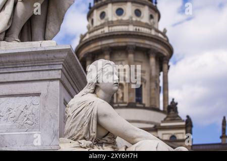 Weibliche Statue mit der französischen Kathedrale im Hintergrund Stockfoto