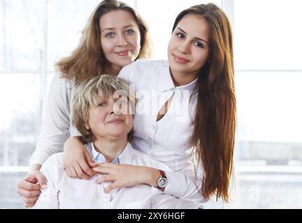 Nahaufnahme Porträt einer erwachsenen Mutter, einer erwachsenen Tochter und einer Teenager-Enkelin, die zu Hause nahe sind und glücklich und fröhlich sind Stockfoto