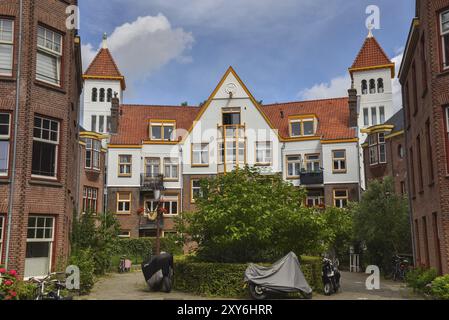 Amsterdam, Niederlande. Juni 2022. Details und Fassaden der charakteristischen Backsteinkonstruktion des Wohngebäudes in Amsterdam Schule Stil architec Stockfoto