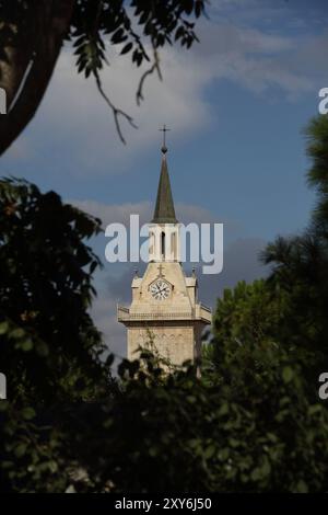 Uhrenturm der Franziskanerkirche St. Johannes des Täufers oder St. Johannes in den Bergen unter Wolken, erbaut an der Stelle, an der Johannes der Täufer geboren wurde Stockfoto