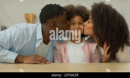 Afroamerikanisches Familienporträt lächelnd Liebe liebevoll verbinden Beziehung birassisch glücklich zusammen in der Küche zu Hause Mutter Vater mit Tochter Stockfoto