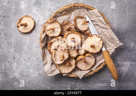 Bio-Shiitake-Pilze in einem Korb mit Messer Stockfoto