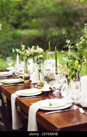 Dekoration der Hochzeitstafel mit Kristall Vasen, Blumen und Zweige in der botanischen Art im Garten Stockfoto