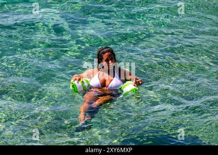 Eine dreißigjährige Frau, die in der warmen Adria im Urlaub in Cavtat, Dalmatien, Kroatien schwimmt Stockfoto