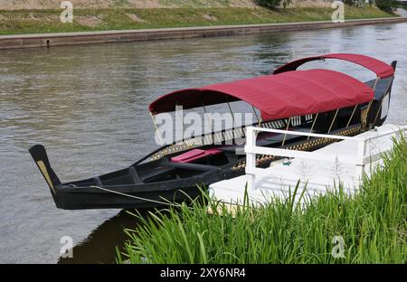 Ruderboot-Gondel in der Nähe des weißen hölzernen Piers am Stadtkanal Stockfoto