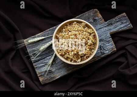 Traditionelles türkisches Essen Bulgur Pilaw mit Gerstennudel in Schüssel auf hölzernem Hintergrund Stockfoto