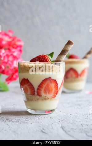 Magnolia Dessert mit frischen Erdbeeren in Glastasse, hausgemachtes milchiges Dessert-Konzept Stockfoto
