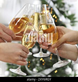 Weihnachten oder Silvester feiern. Menschen halten Gläser Champagner macht einen Toast mit dem Weihnachtsbaum Stockfoto