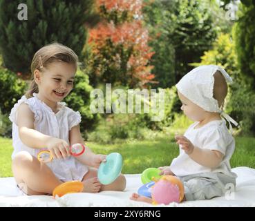 Zwei spielende kleine Schwestern im Sommergarten Stockfoto