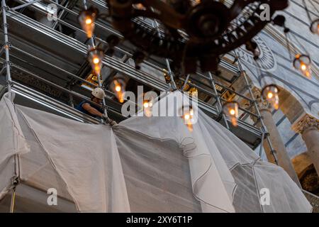 Siena, Italien - 14. Juli 2024: Renovierungsarbeiten im Inneren des Duomo di Siena (Santa Maria Assunta), hängende Kirchenbeleuchtung und Kunstwerke der Kuppel Stockfoto