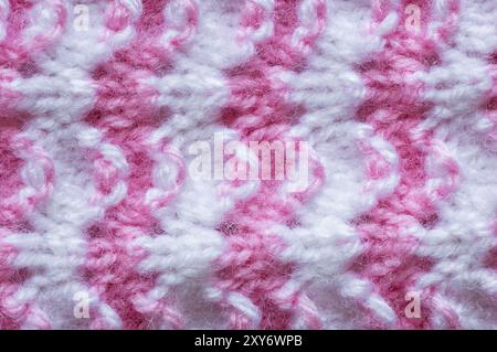Muster von rosa gestrickter handgemachter Babykleidung, Strickmuster Hintergrund, gestrickte Textur Hintergrund Stockfoto