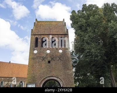 Alter gemauerter Kirchturm mit drei Glockenschlitzen und umliegender Natur, Bad Zwischenahn, ammerland, deutschland Stockfoto