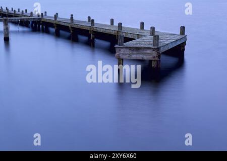 Alte Holzpier im Wasser bei Sonnenuntergang in Groningen, Niederlande Stockfoto