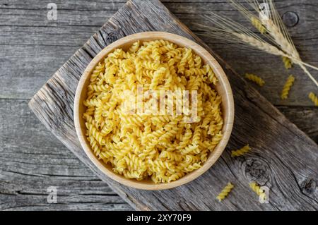 Rohe Schneckennudeln in Schüssel oder Löffel, ungekochte Fusilli mit Weizen Stockfoto