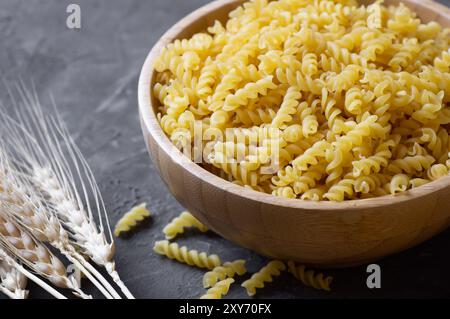 Rohe Schneckennudeln in Schüssel oder Löffel, ungekochte Fusilli mit Weizen Stockfoto