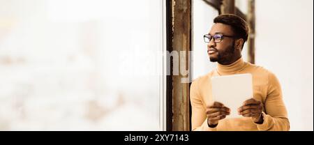 Träumender Afro Manager mit wegschauendem Tablet Stockfoto