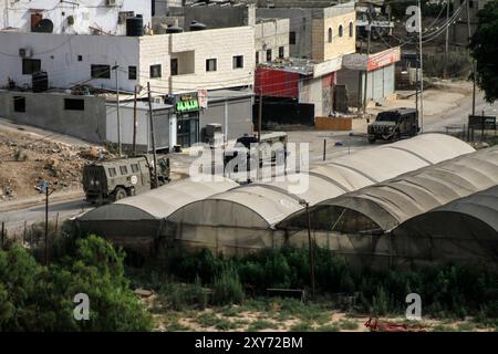 Jenin, Palästina. August 2024. Israelische Militärfahrzeuge konzentrieren sich während des Überfalls in der Stadt Dschenin, nördlich der besetzten Westbank. Israelische Truppen überfielen die Städte Dschenin, Tubas, Tulkarm und das Flüchtlingslager Far'a, wobei Tausende israelische Soldaten gleichzeitig an den Überfällen teilnahmen. Elf Palästinenser wurden getötet, Dutzende verletzt und Infrastruktur, Straßen und Häuser zerstört. Quelle: SOPA Images Limited/Alamy Live News Stockfoto