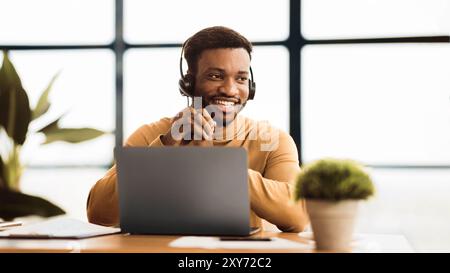 Glücklicher Afro-Manager, der im Callcenter arbeitet Stockfoto