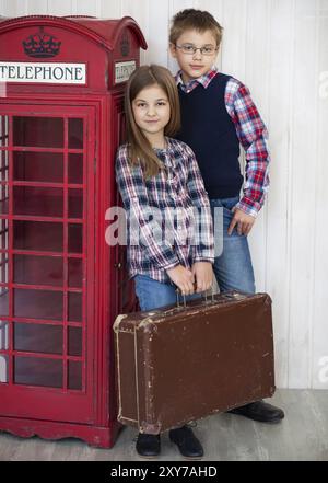 Porträt eines glücklichen Mädchens und eines lächelnden Jungen mit Anzug. Reise-Concapt Stockfoto