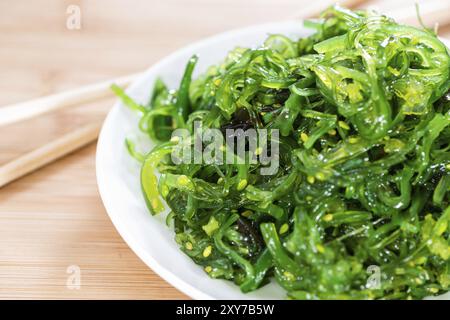 Gesunden Seetang Salat in einer Schüssel auf hölzernen Hintergrund (close-up erschossen) Stockfoto