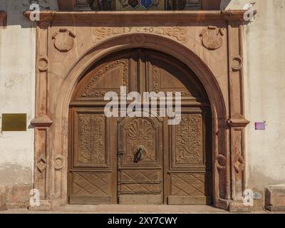 Ein kunstvoll geschnitztes Holztor in einem historischen Gebäude verleiht rustikalen Charme, Weissenburg, Elsass, Frankreich, Europa Stockfoto