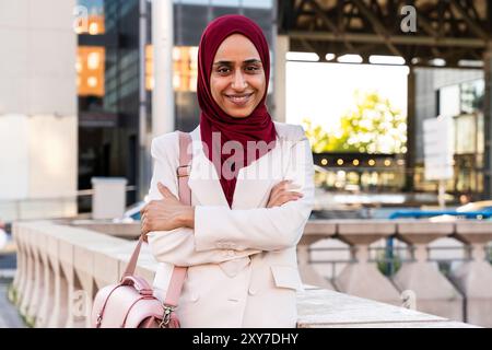 Schöne arabische Geschäftsfrau mit Hijab und elegantem Business-Anzug Porträt in der Stadt - erwachsene Frau aus dem Nahen Osten, die selbstbewusst in die Kamera wi blickt Stockfoto