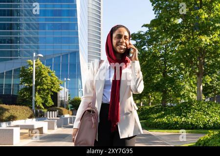 Schöne arabische Geschäftsfrau mit Hijab und elegantem Business-Anzug Porträt in der Stadt - Erwachsene Frau aus dem Nahen Osten auf Geschäftsreise zu Fuß und Stockfoto