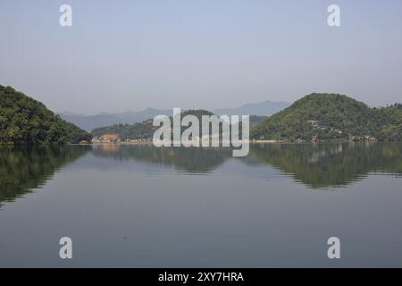 Morgenszene am Begnas See, Nepal. Hügel bedeckt von Wald im Wasser, Blick von Majhjkuna. Landschaft in der Nähe von Pokhara Stockfoto