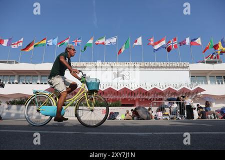 Venedig, Italien. August 2024. Ein Mann reitet am Palazzo del Cinema auf der Insel Lido in Venedig, Italien, 28. August 2024. Das 81. Filmfestival von Venedig findet vom 28. August bis zum 7. September auf der Insel Lido von Venedig statt. Quelle: Li Jing/Xinhua/Alamy Live News Stockfoto