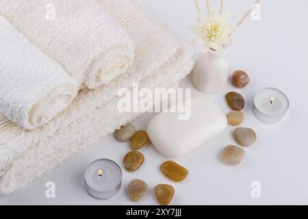 Spa und Wellness Einstellung Seife, weiße Handtücher blumen Steine Kerzen aroma Sticks weißer Hintergrund Stockfoto