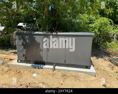 Die Installation des Erdgas-Propan-Standby-Generators für den privaten Gebrauch wurde im Hinterhof abgeschlossen Stockfoto