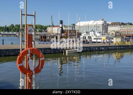 Hafen mit Booten, einem Rettungsschirm und Stadtgebäuden am Ufer, Helsinki, Finnland, Europa Stockfoto