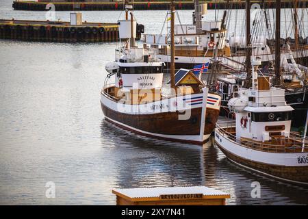 HUSAVIK, ISLAND, 29. JUNI: Am 29. Juni 2013 in Husavik verankerte Walbeobachtungsschoner bei Sonnenaufgang im Hafen von Husavik und in den Bergen im Hintergrund, Stockfoto