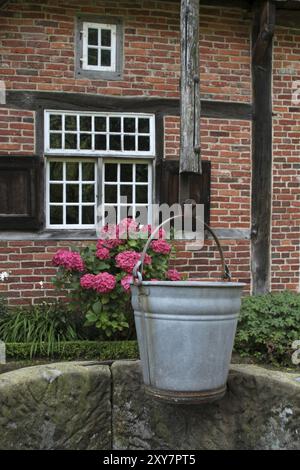 Er zeichnet gut vor einem Fachwerkhaus Stockfoto