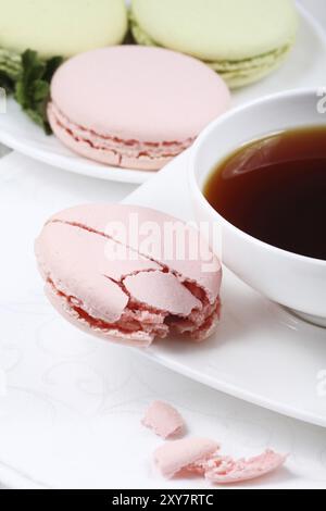 Tasse Kaffee und Makronen auf weißem Hintergrund Stockfoto