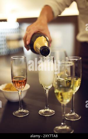 Eine Reihe von Champagner-Flöten sind auf einem Tisch und Chips gefüllt Stockfoto