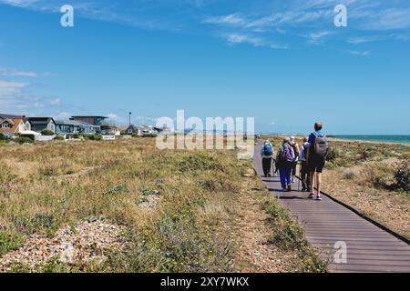 Eine Gruppe älterer Spaziergänger auf der Promenade am Shoreham Beach an einem heißen Sommertag West Sussex England Großbritannien Stockfoto