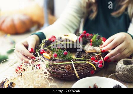 Weihnachten handgefertigte Kranz in jungen womans Hände. Winterurlaub feier Konzept Stockfoto